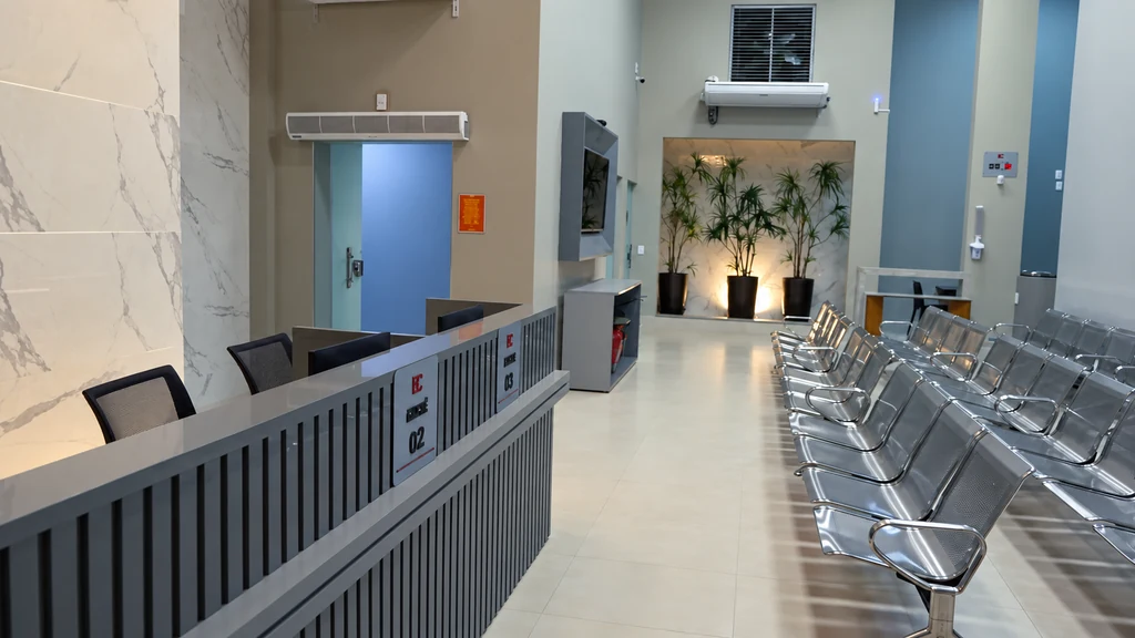Sala de espera da EmCORR com cadeiras, balcão e jardim interno